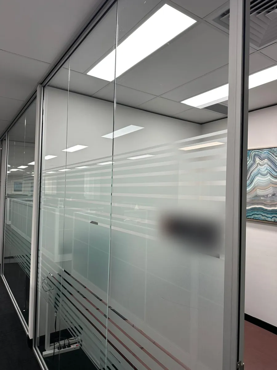 Frosted glass partition along an office corridor