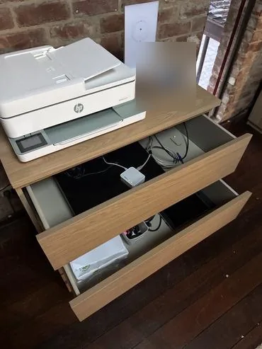 Two drawers left partly open beneath a printer to improve airflow