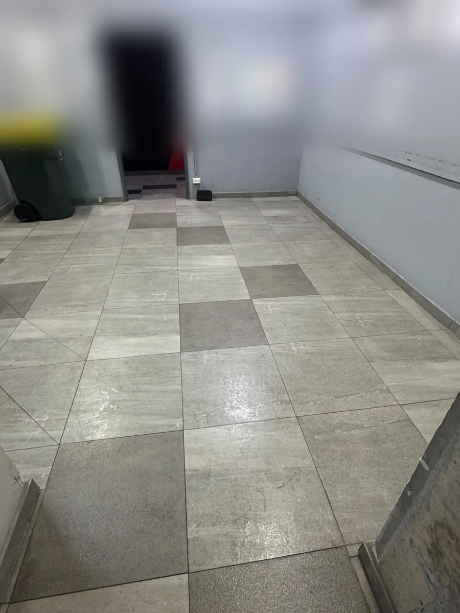 Mopped tiled floor of an apartment building bin room