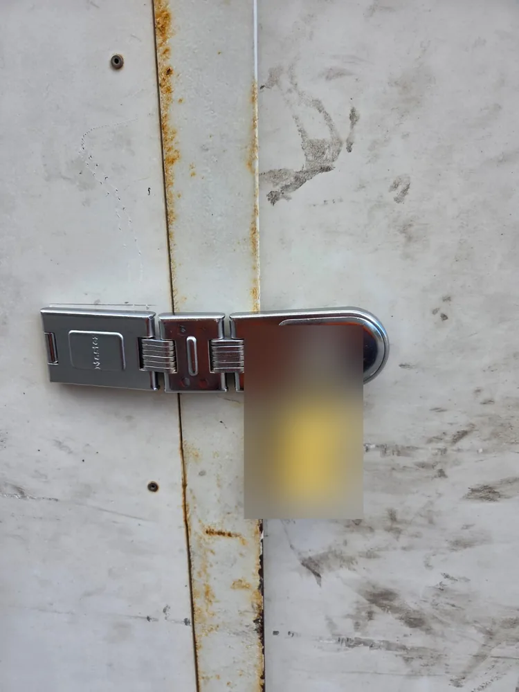 Heavy duty hasp and staple with a combination padlock across the bin store door seam
