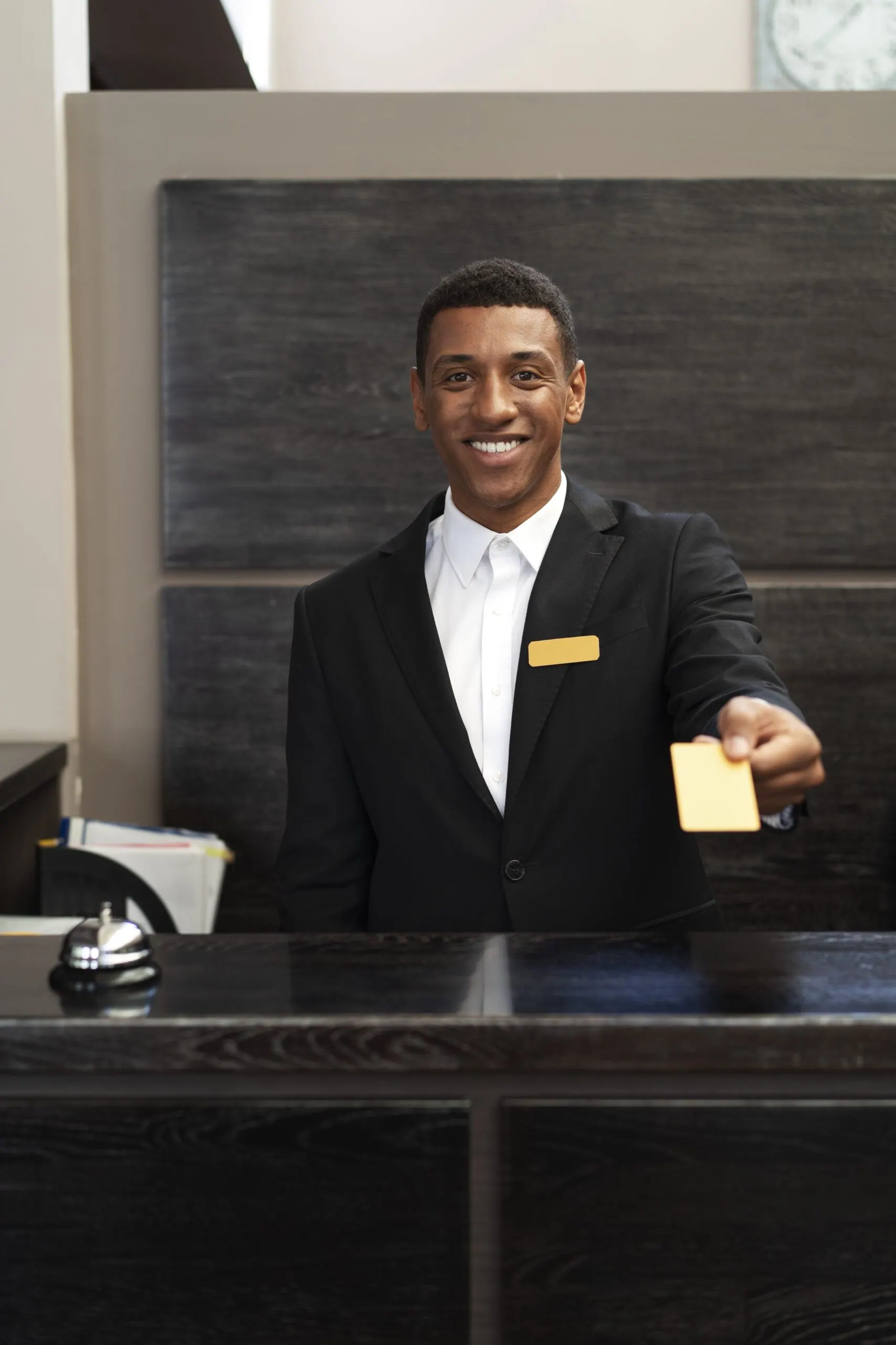 Reception staff member handing over a key or item at the front desk