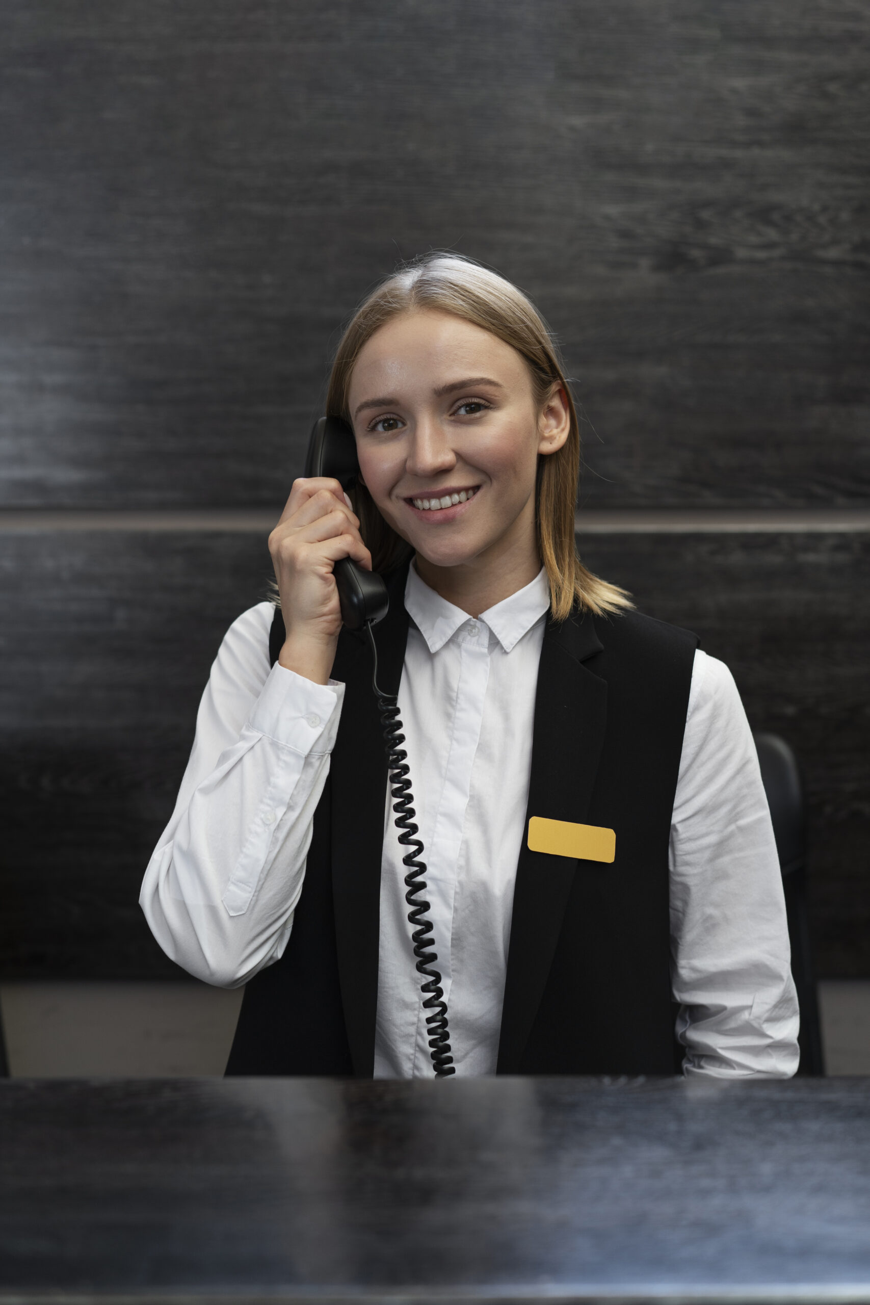 Concierge receptionist in elegant attire at a premium apartment building desk