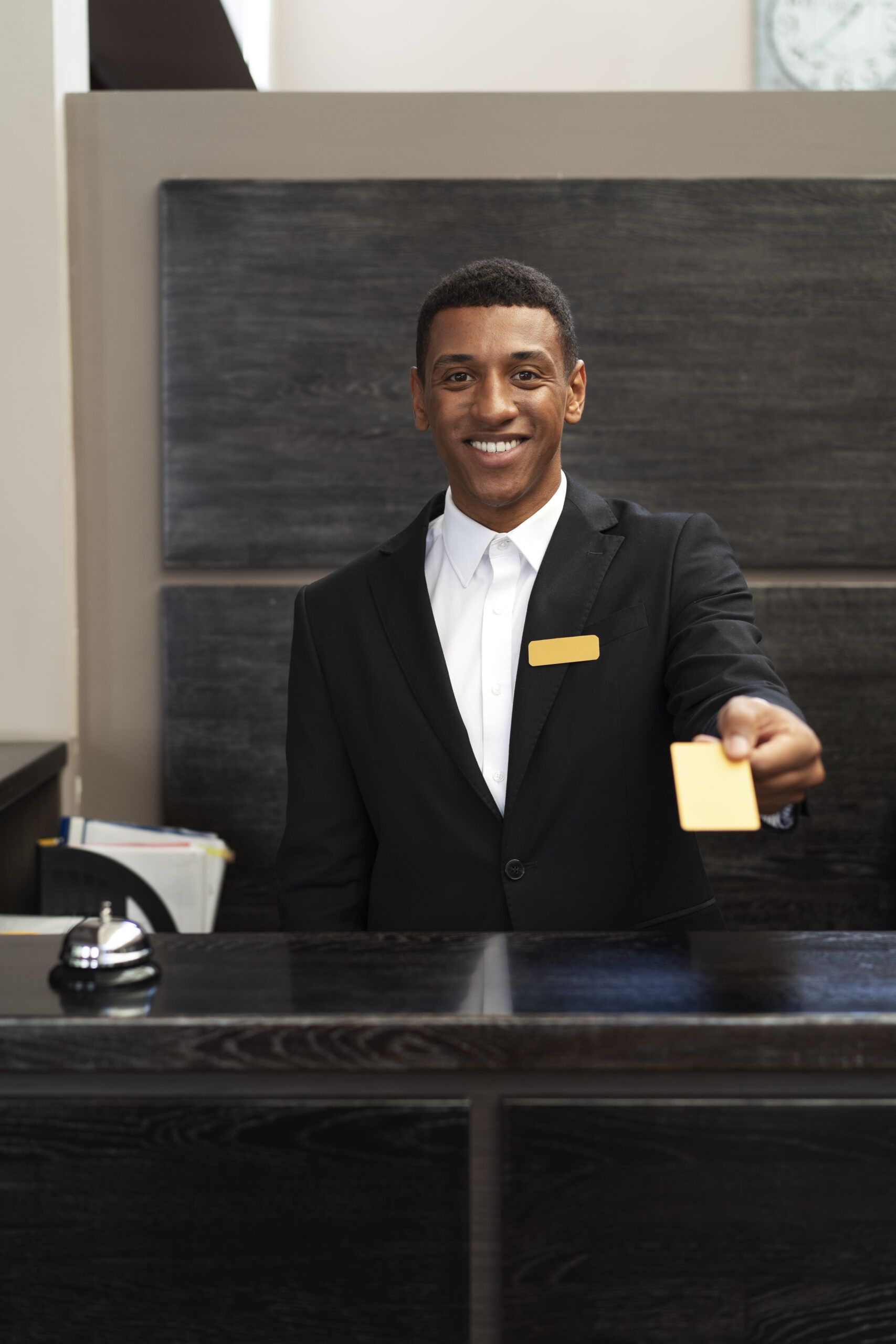 Reception staff member handing over a key or item at the front desk