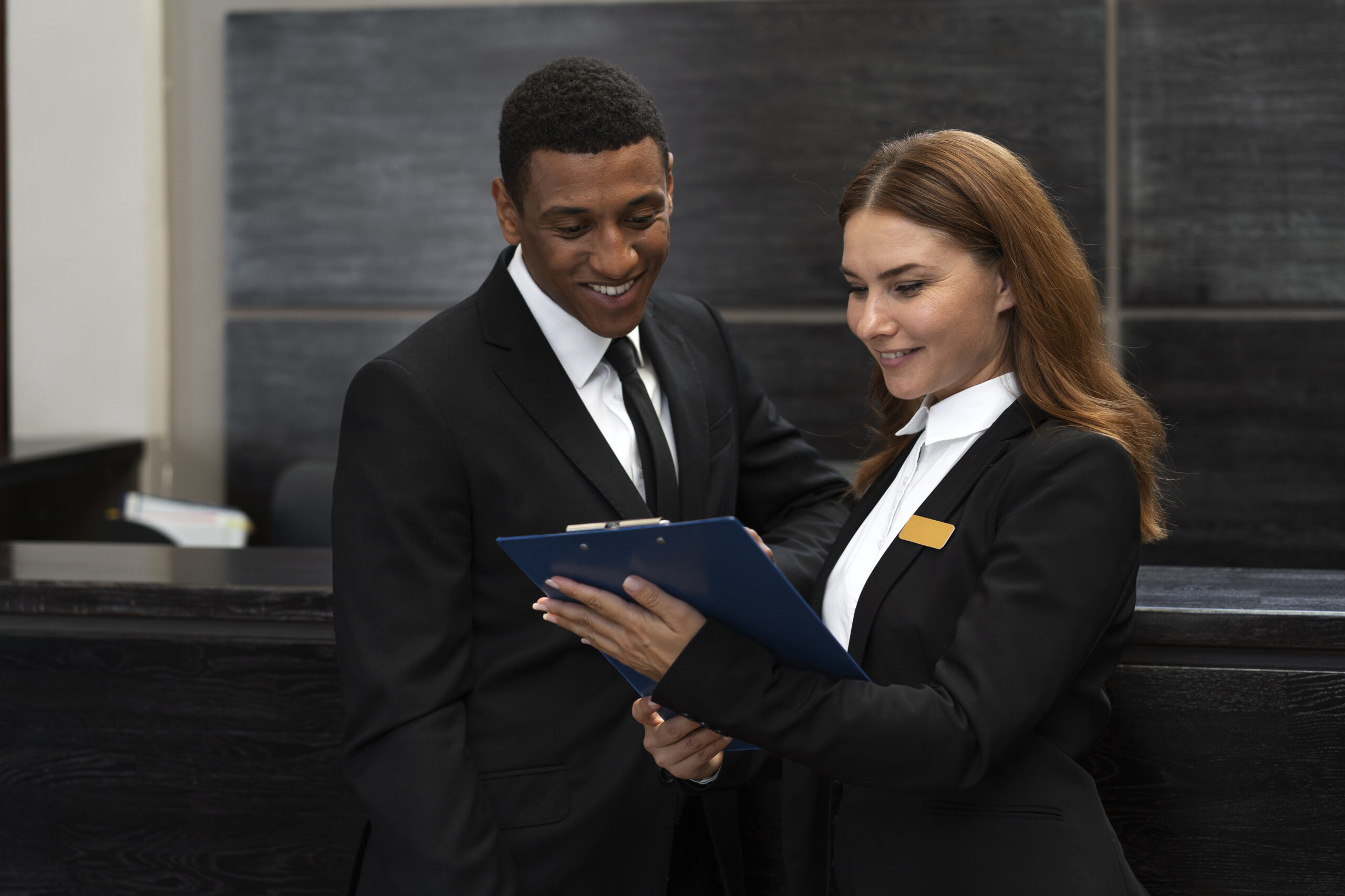 Reception staff in elegant uniforms working at a commercial building front desk