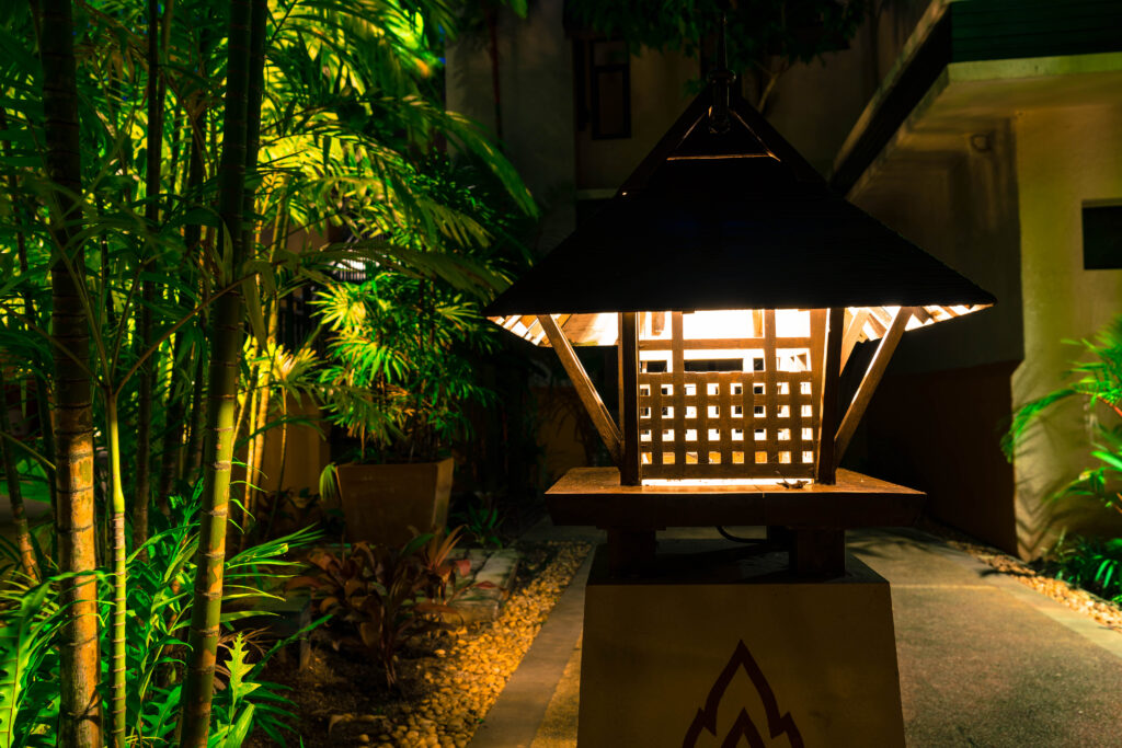 Backyard at dusk with string lights hung over a seating area and solar lights lining the path.